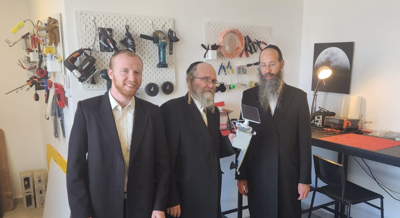 Handing over the solar-powered eruv monitoring prototype for community representatives to evaluate